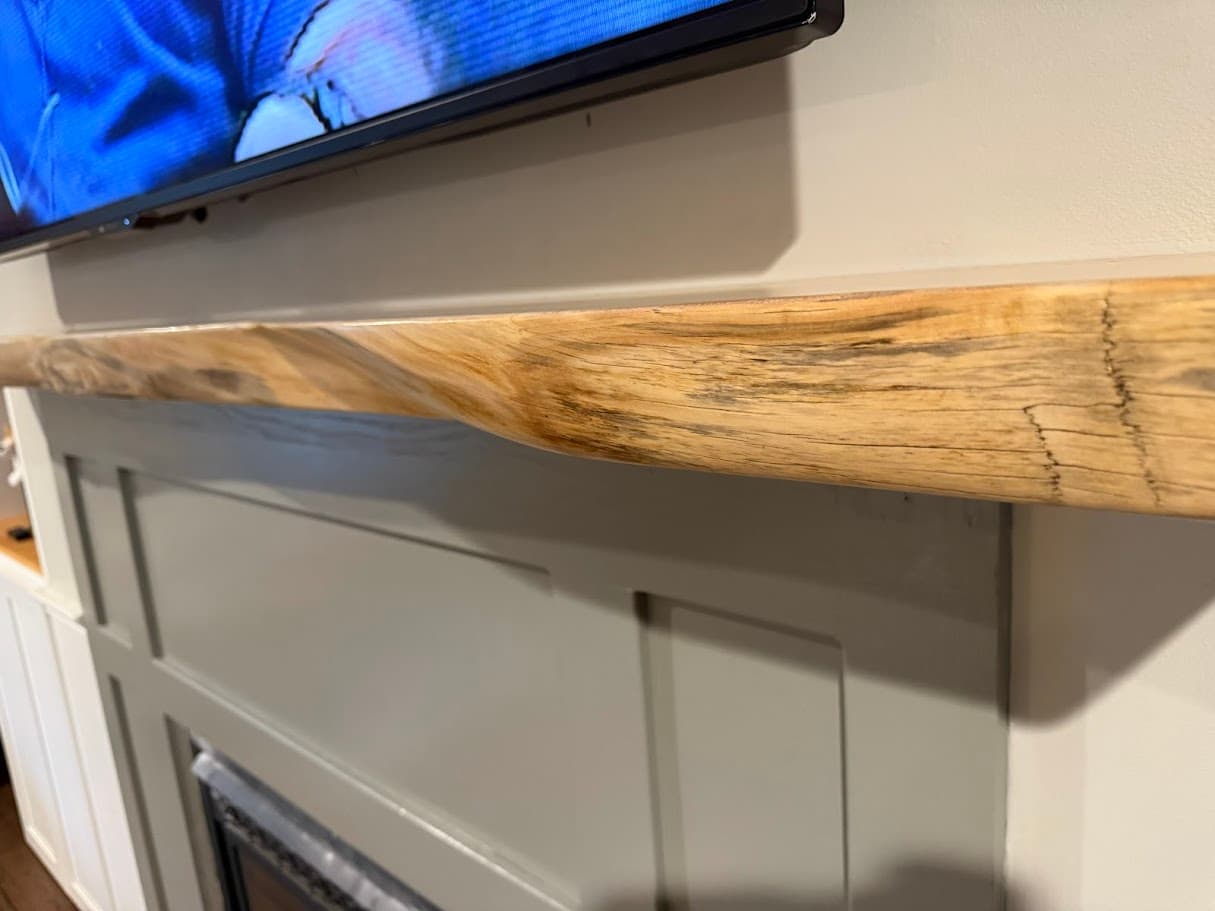Wood mantel on stone fireplace